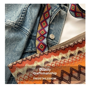 Detail of woven ethnic shoulder bag with colorful geometric strap and warm wave patterns