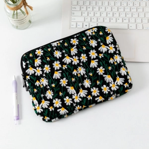 Close-up of quilted laptop sleeve with white daisy embroidery and black zipper detail