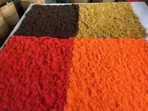 Detail of square artificial moss sheets in brown, yellow, red and orange textures