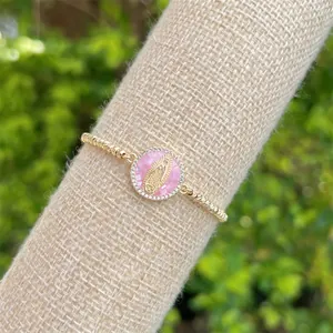 Macro detail of gold-plated bracelet with Virgin Mary cameo and zircon accents