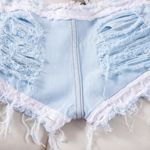 Primer plano de pantalones cortos vaqueros azul claro con rotos y bajos con flecos