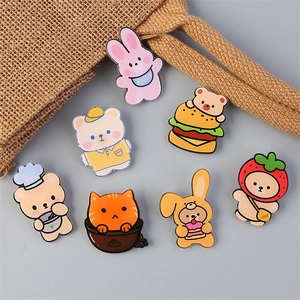 Set of seven cute cartoon enamel pins including bears and rabbits on blue background