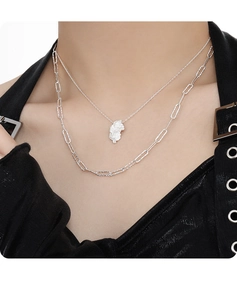 Detail of layered S925 silver necklace with irregular lava pendant and paperclip chain