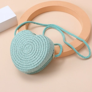Detail of blue heart-shaped woven straw crossbody bag with zipper and spiral texture