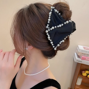 Détail d'une pince à cheveux nœud en soie noire française avec bordure en perles blanches