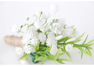 Detail of white artificial gypsophila boutonniere with rustic twine and green leaf