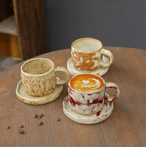 Detailed close-up of handmade ceramic coffee cups with marble texture on a wooden table