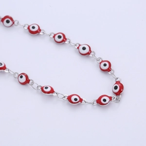 Classic red enamel evil eye bracelet crafted with stainless steel links on white surface