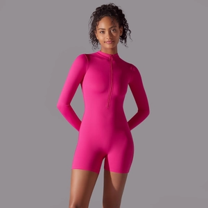 Detail of hot pink long sleeve yoga romper featuring a functional front half-zipper design