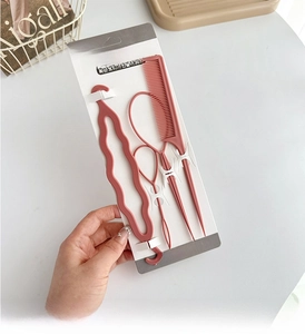 Pink hair styling tool set featuring tail comb and hair loop tools on brand card