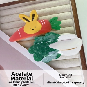 Detail of vegetable claw clips showing the marbled acetate texture and carrot rabbit design