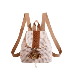Beige straw backpack with brown leather tassels and tassels on a clean white background