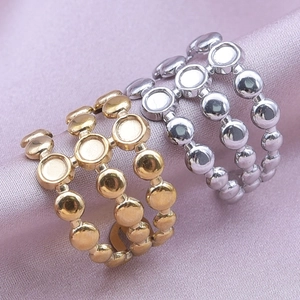 Macro shot of gold and silver stainless steel triple layer round ring base settings on silk