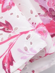 Vue macro du tissu blanc avec imprimé floral et détails de broderie anglaise raffinés