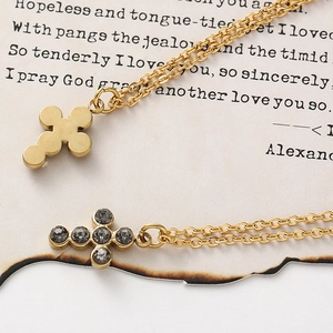Detail of gold cross necklaces with polished finish and crystals on vintage paper