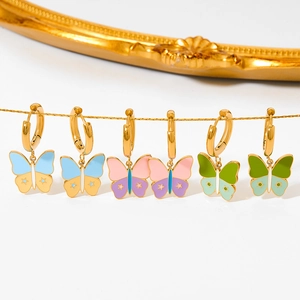 Chic gold butterfly hoop earrings with colorful enamel charms on a white background