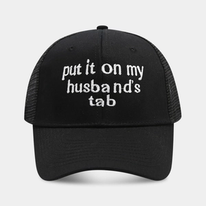 Detail of black trucker hat featuring white embroidery and breathable mesh back panel