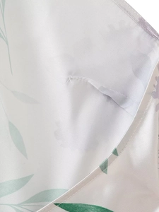 Détail du tissu en soie blanche avec motifs de feuilles vertes et coutures soignées