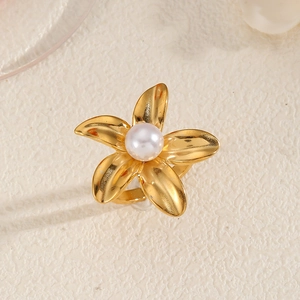 Macro view of 18K gold plated flower ring with textured petals and center pearl inlay