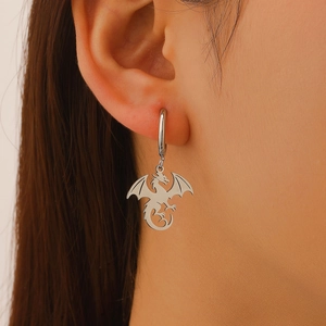 Vue rapprochée des boucles d'oreilles dragon argenté gothique portées avec détails précis