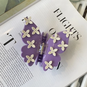 Elegant purple butterfly hair claw clip with white flowers and sparkling rhinestones