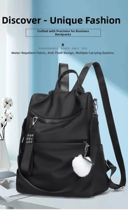 Detail of black nylon backpack featuring silver zippers and white pompom charm