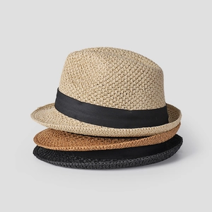 Vertical stack of hand-woven straw fedora hats in beige, brown and black with black ribbons