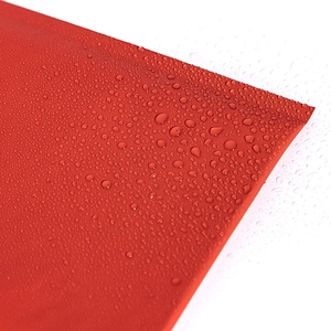 Waterproof red kraft bubble mailer showing water droplets on premium paper surface