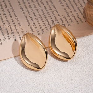 Polished gold metal drop earrings in a minimalist leaf design for a vintage luxury aesthetic