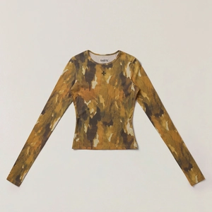 Gros plan sur le haut moulant en soie côtelée avec imprimé camouflage et broderie logo