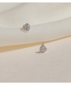 Macro shot of S999 sterling silver heart stud earrings with pink gemstone and white crystals