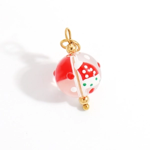 Detail of Christmas theme bead pendant with festive hat pattern and gold metal components
