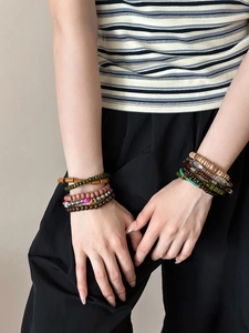 Détail de bracelets multicouches bohèmes avec des perles en bois vintage et pierres naturelles