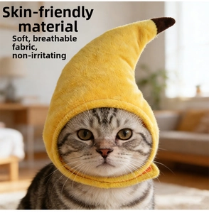 Detail showing the soft plush banana hat texture and adjustable chin strap on a cat