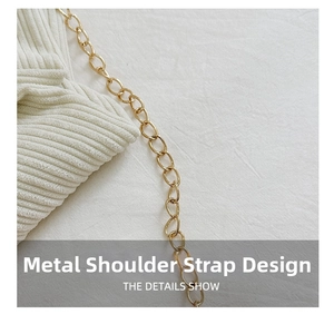 Detail shot of a golden metal chain strap on white ribbed knit fabric texture
