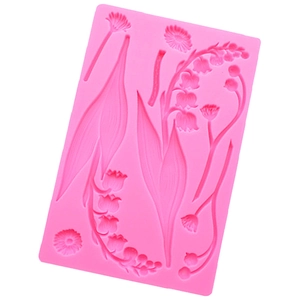 Detail of pink silicone mold featuring intricate floral and leaf branch patterns for baking