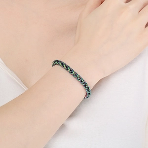 Close-up of rainbow stainless steel curb chain bracelet worn on a model's wrist