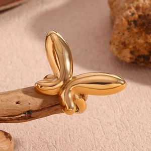 Vue macro d'une bague papillon en acier inoxydable plaqué or 18 carats sur une branche