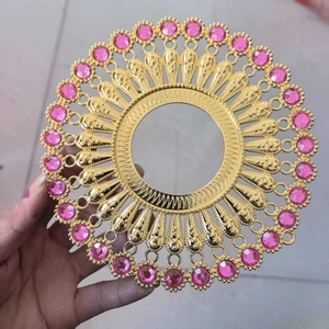 Detailed view of a gold metal ring accessory featuring pink rhinestones and a hollow center