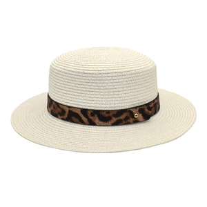 Dettaglio ravvicinato di un cappello paglia crema con nastro leopardato e borchia oro