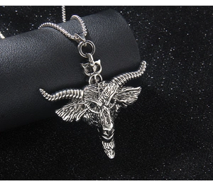 Macro detail of silver stainless steel bull head pendant with engraved pentagram design