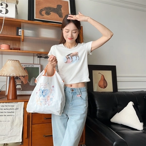 Détail du sac cabas en toile blanche avec imprimé papillon bleu et broderie florale
