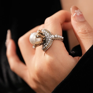 Detailed close-up of vintage flower pearl ring featuring a large center pearl in gold finish