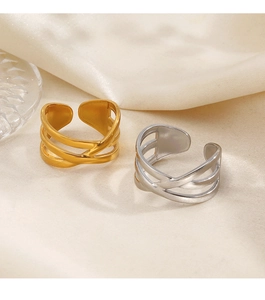 Detail view of gold and silver layered interlocking rings on soft silk fabric background
