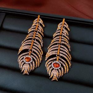 Detailed close-up of vintage feather drop earrings with amber stones and crystals
