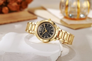 Détail d'une montre femme avec cadran noir et lunette en cristal sur marbre blanc
