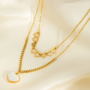 Détail du collier double rang doré avec pendentif cœur en opale blanche irisante