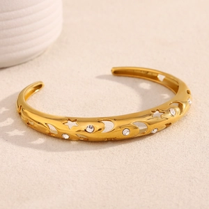 Close-up of 18K gold plated bangle with hollow star moon motifs and clear zircon stones