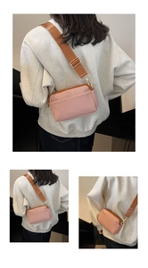 Detailed view of pink PU crossbody bag with adjustable wide brown strap and gold zippers