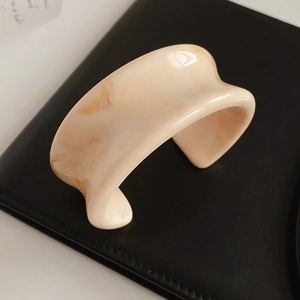 Detail shot of marble pattern resin cuff bracelet with cream and brown swirling texture